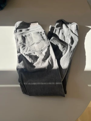 Grå jeans från Replay - Snygga grå jeans från Replay med klassisk femficksdesign och detaljerad bakficka. Jeansen har en rak passform och är tillverkade i slitstarkt denimtyg. Perfekta för dig som gillar en stilren och tidlös look. Det är i mycket bra Scick säljer då de va för små hör av er vid funderingar kan gå ner i pris vid snabb affär