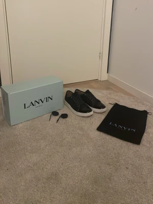Svarta Lanvin sneakers med vit sula - svarta Lanvins med glans. allt og utan kvitto. Skorna e köpta från hemsidan dom e lite använda men ser typ helt nya ut. Skorna kommmer me extra snören och box. Skorna kommer impregnerade så dom håller sej bättre om dom blir blöta. Priset e inte hugget i sten👍 svarar på alla frågor.👍
