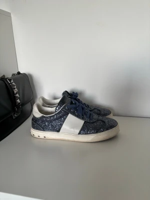Valentina fly crew sneakers - Såå snygga valentino garavani fly crew skor i storlek 39. Alla nitar är kvar. De är använda men i bra skick med lite slitage på vita delarna på sidorna (bild 7) samt på de blåa remmarna (bild 8). Man får med extra skosnören.