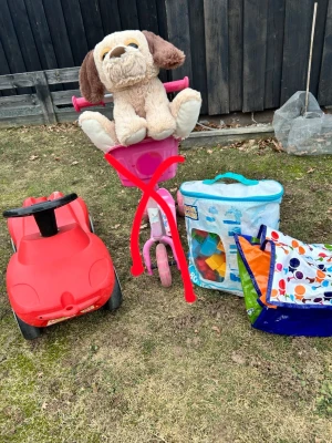 Leksakspaket med bil och gosedjur - Säljer ett paket med en röd leksaksbil i plast,  ett stort mjukt gosedjur i form av en hund samt en förvaringsväska med byggklossar och en färgglad lektunnel. Perfekt för utomhuslek och fantasi! Sparkcykeln är såld! 