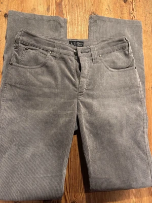 Armani manchesterbyxor - Gråa manchesterbyxor i märket Armani. Som nya. Modell: Mid rise och lätt utsvängda nere vid benen. 79 cm innerbenslängd och 35 cm rakt över midjan🩷