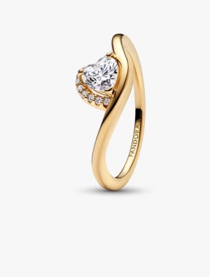 Pandora ring i guld med hjärtformad sten - Snygg ring från Pandora i guldplätering med en stor hjärtformad klar sten och små gnistrande stenar längs ena sidan. Ringen har en elegant, böjd design som ger en modern och romantisk känsla. Perfekt för dig som vill sticka ut med något extra.
