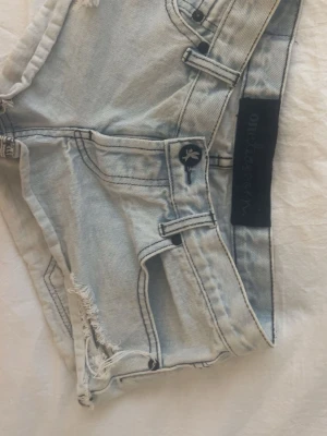 Ljusblå denimshorts från One Teaspoon - Ljusblå low waist jeansshorts i fin denim från one teaspoon🩷 Diskreta slitningar och rå kant som ger en stilren, avslappnad look.  Sitter lågt på höften, Lowwaist modell. Enkel men snygg modell som funkar till det mesta – perfekt till sommaren ☀️  Storlek: ca 34 Skick: mycket fint skick Färg: ljusblå  Hör gärna av vid prisförslag eller frågor🩷🙏🏼