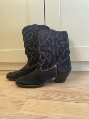 Svarta cowboy boots i mocka - mocka cowboy boots fodrade med dekorativa vita sömmar. Väldigt mörkblå så typ svarat ut. Vintage. 