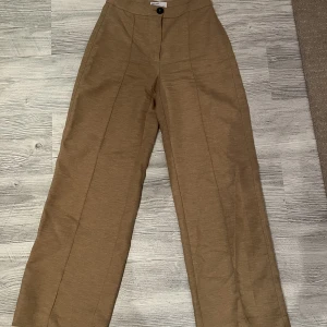 Beiga/bruna kostymbyxor - Beige/bruna  kostymbyxor med vida ben  Säljes pga för små
