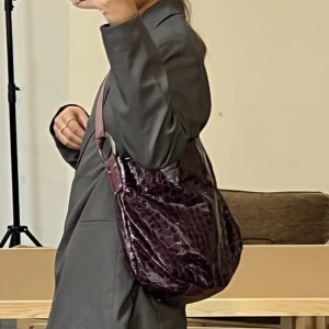 Lila väska - Lila väska som går att ha både på Axén och över kroppen som på bilderna. Köpt second hand men i väldigt fint skick. Har inne fickor och en fickor på utsidan! 💜 Får plats med dator i!