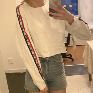 Levis Cropped Sweater  - En vit sweater från Levis. Den är cropped och blir lite som en magtröja. Inga fläckar! Den är storlek S men jag som brukar ha Medium passar den ändå. Den är ganska luftig/oversize i bredden. 