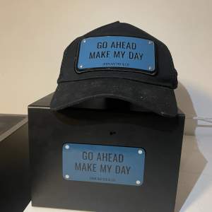 En John hatter keps som har skriften” Go Ahead Make my day” skriv om du är intreserad eller har några frågor