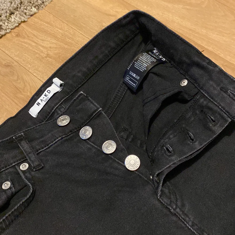 Svarta straight jeans från NA-KD. Det är knappar ist för en dragkedja vilket är en fin detalj. Lite urtvättade men har ändå hållt en fin färg trots flera tvättar. . Jeans & Byxor.