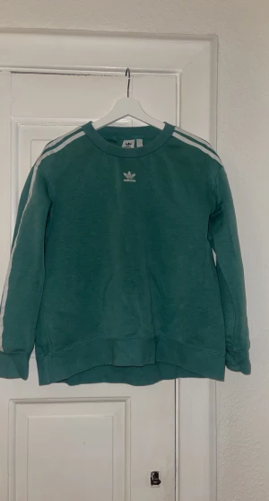Adidas sweatshirt - Grön oversize tröja från Adidas, sparsamt använd. Strl 34