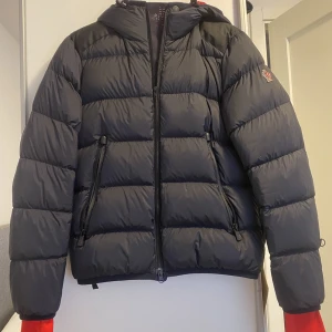 Väldigt fin Moncler vinterjacka - En otroligt fin och varm Moncler Grenoble Hintertux jacka säljes till riktigt bra pris. Finns en liten skada på ena ärmen som nog går att laga för en billig peng. Helt ny dragkedja också   Köpt på NK 2021. Jackan säljes på NK idag för 15000kr