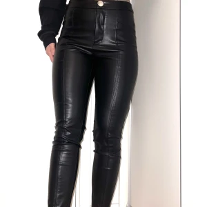 Skinbyxor - Skinbyxor som är helt nya, oanvända. Silverknapp upptill, lite högre i modellen. Går att öppna upp nedtill med dragkedja i benen. 