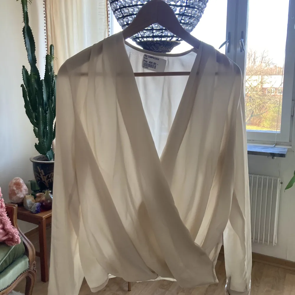 Vacker vit blus i sidenmaterial, aldrig använd. Ej så transparent på som den framstår på bild 1. Väldigt skön. Passar både xs och s. Originalpris 499 kr, syns om man zoomar in lite på bild 1. Kan mötas upp, annars är frakt möjligt (billig frakt pga lätt).. Puserot.
