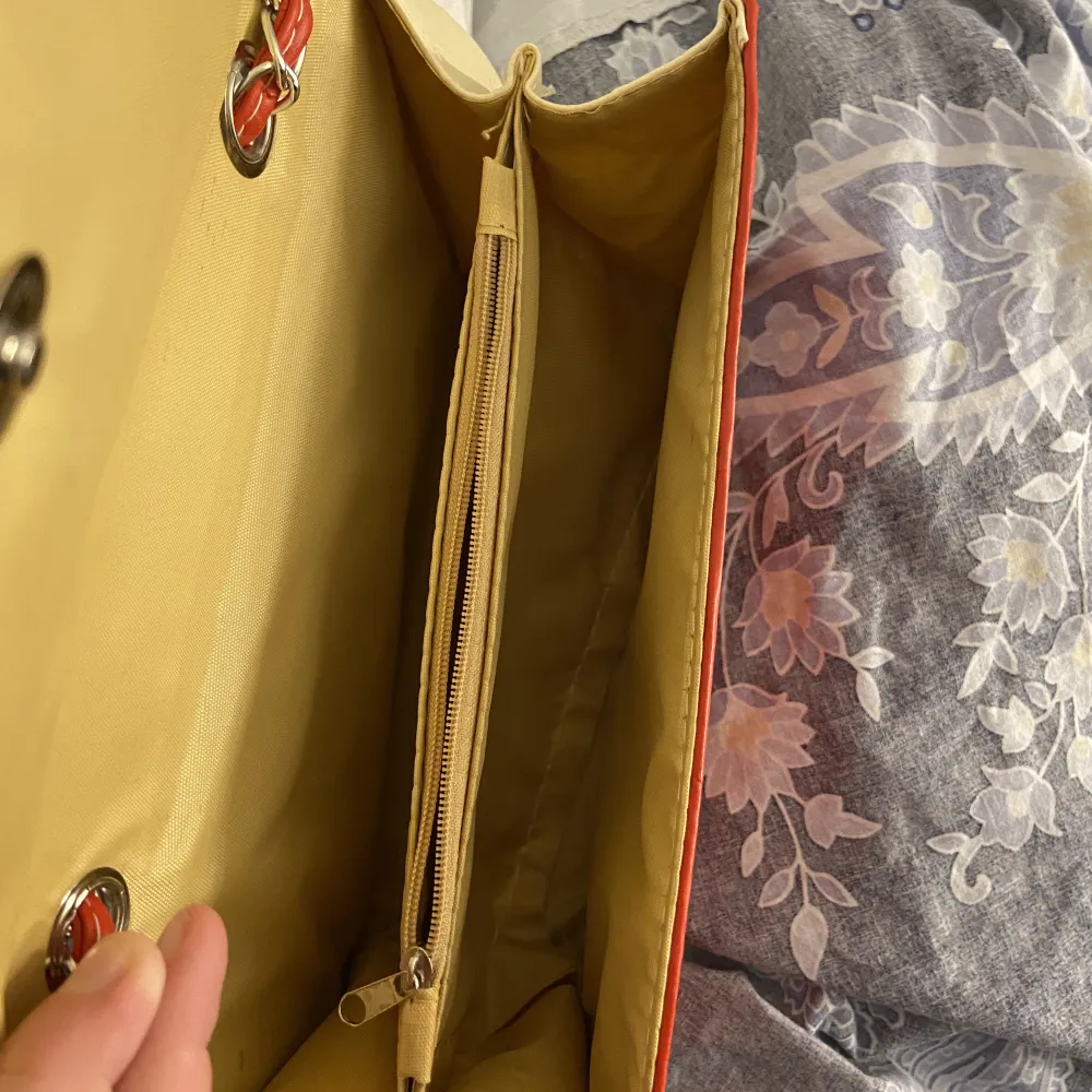 Röd väska med ställbart band, kan både va långt och ställa till två kortare band. . Väskor.