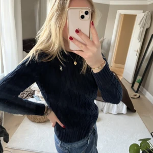 Ralph Lauren stickad tröja S marinblå - Säljer nu min marinblåa stickade tröja från Ralph Lauren i storlek S. Jättefin att ha över en klänning på sommaren eller bara till ett par jeans☺️knappt använd! Säljer för 300kr🥰