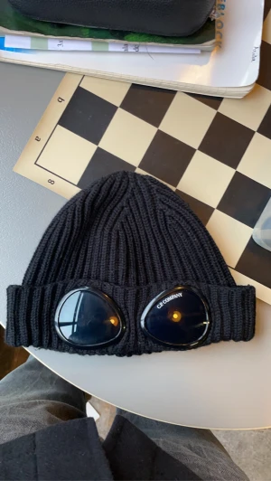 Cp company mössa - Svart cp company mössa, Lappen är lite sönder men utöver det är den felfri, Kvitto finns kvar