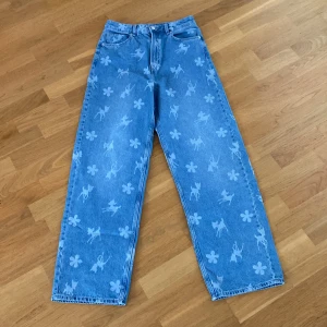 Jeans med figurer - Jag säljer ett par helt oanvända jeans i nyskick. De har ett rådjur och en blomma på sig. Längden på de är 108cm. Orginalpriset är 349kr. Hopppas de får någon ny ägare!💓
