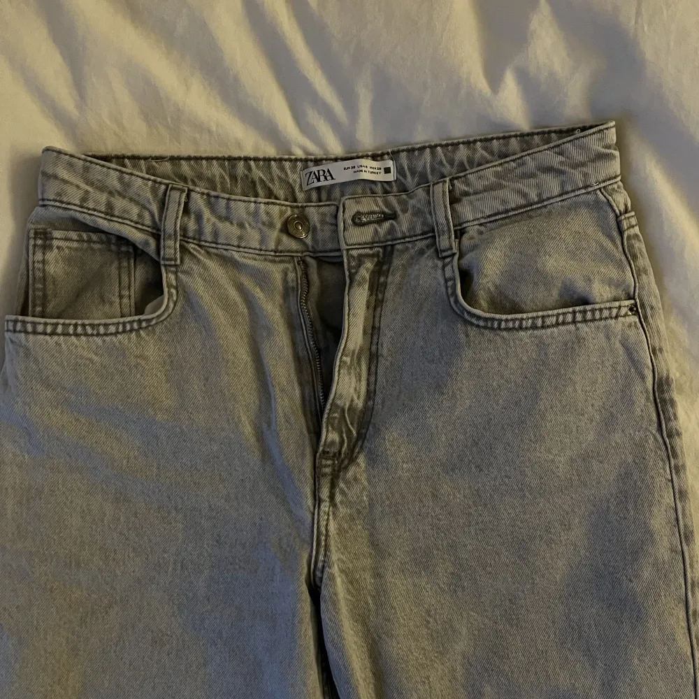 Supersnygga gråa midwaist zara jeans med slits. Jättefint skick. Säljer då de tyvärr är för små för mig.. Jeans & Byxor.