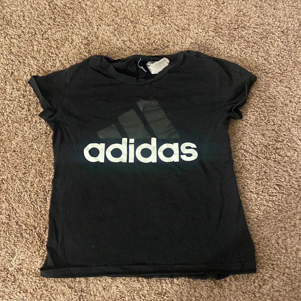 En svart adidas t-shirt i storlek 12-13 år gammal. . T-shirts.