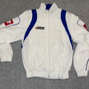 Lotto jacka storlek M - Vit windbreaker / vindjacka från Lotto. Ganska använd men inga slitningar. Storlek M och passar bra.  