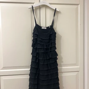 Sandro klänning - Så fint svart sandro klänning med volanger! Den har en resår i midjan, storlek 38!