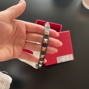 Valentino armband - Säljer mitt valentino armband som är i superfint skick!! Svart med guldiga nitar, kartong & dustbag finns med!! & alla kvitton 