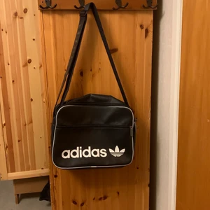 Adidas väska  - Mörkblå adidas väska i fint skick köpt second hand. Bra med utrymme perfekt för att ha dator i, justerbart axelband.