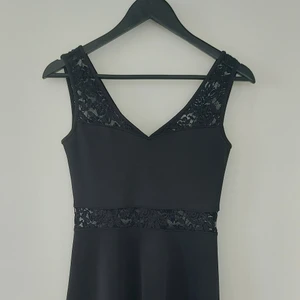 Klänning med spets - Fin klänning med spetsdetaljer på ryggen. Priset är exklusive fraktavgift. 