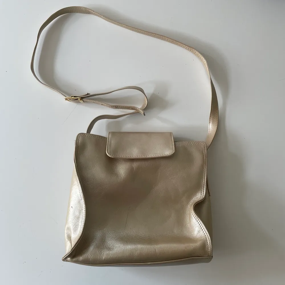 Handväska i guldigfärg! Köpt secondhand men sparsamt använd, naturligt slitage se bild 🫧 . Väskor.