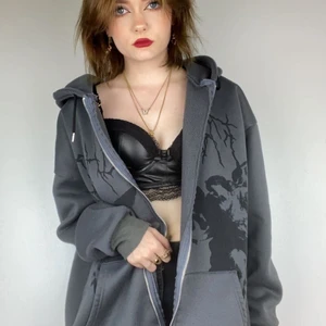 Grunge hoodie - Lång grå hoodie med coolt tryck på. Riktigt grunge. Dragkedjan är tyvärr sönder och det finns tre eller fyra blekta fläckar i men inget som syns utanpå. (Se bild tre)  Köpare står för frakt. Kan mötas men Swish funkar likasåväl. 