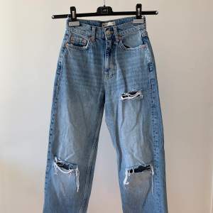 Säljer ett par jättefina jeans från Ginatricot med slitningar på benen. Aldrig använda! Jeansen är i petite (storlek 30) och hyfsat högmidjade. Jättefin blå färg! Köparen står för frakt.