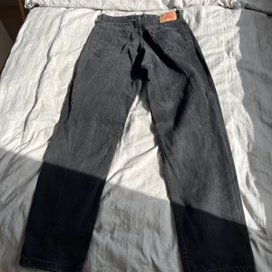 Svarta Levis jeans - Säljer dessa svarta Levis jeans modell 550 relaxed. Midjan är 34, men jag tycker att de är lite mindre än så, dessutom kan de dras ner till höfterna och passar då de med mindre storlek bra. Längden är 32 ❤️‍🔥