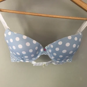 Blå BH med vita prickar stl 75B - Använd fåtal gånger! Super gullig och bekväm BH med en roset och en rosa knapp i mitten <3