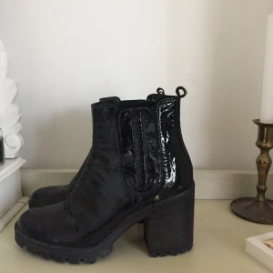 Svarta glansiga boots strl 37 - Svarta boots i glansigt fake-läder. Fint men använt skick!