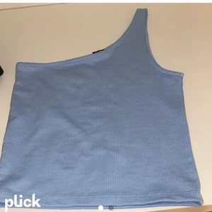 One shoulder topp - Säljer min blåa one shoulder topp som är helt oanvänd och är super fin till sommaren. Den är ganska tjock så man ser inte igenom 