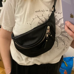 Svart magväska från Boohoo  - Säljer en svart magväska från Boohoo med silvriga detaljer. Aldrig använd så bra skick! 