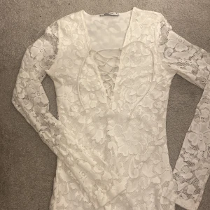 Vit fin klänning - Vit spetsig klägging tajt med snörning vid brösten. Pris kan diskuteras