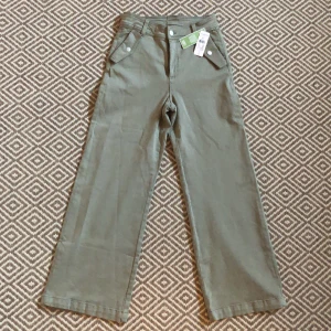 Oanvända byxor från Kappahl - Oanvända byxor från KappAhl. Prislappen är kvar. Olivgröna/grå. Strl 40. Ursprungspris 499, säljer för 200.