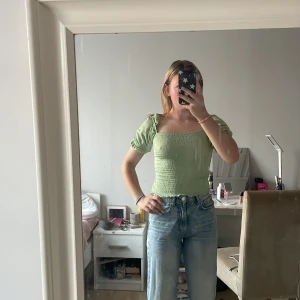  topp från Gina  - Fin topp från Gina tricot. Ribbat material med volang armar. Fint skick. Inga fläckar. Pris är diskuterbart samt paketpris vid köp av fler. Skickas spårbart med Postnord. 