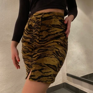 Vintage kjol - Vintage kjol i tigermönster och velvet🧡 finns en dragkedja i midjan som man kan ha både fram eller bak (som på bilderna) Det står ingen storlek men skulle gissa på en S