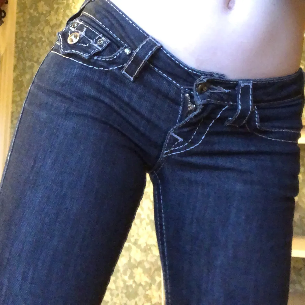 jättefina lowrise bootcut jeans från true religion, i bra skick! midjemått 74, stl 24💞(jag har stl 26 och de passar på mig) jeansen har diamanter som knappar vilket är jättegulligt! skriv till mig om ni är intresserade/ har frågor. Jeans & Byxor.