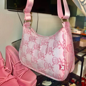 Supersöt Rosa väska mönstrad 🦋💕supersoft material! - Säljer denna supersöta handväska i mjukt tyg med mönster och en fjärilsdetalj. justerbar rosa  rem och rosa glansigt foder. Använd ca 4 gånger, (Köptes på  HM i somras till ett event) inga hål eller fläckar💕 