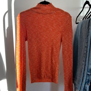 Orange stickad tröja - Säljer en orange stickad tröja från NAKD som tyvärr bara kom till användning en gång. Sitter jättefint på!