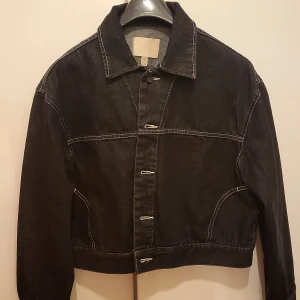 Mörk jeans jacka - Mörk grå jeans jacka andvänd på en fotografering som ny. 