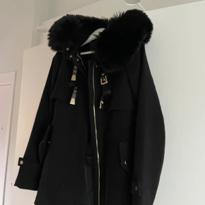 Päls kappa - Svart pälskappa med guld detaljer ( man kan ta av pälsen)  Använd fåtalgånger men som ny Köpare står för frakten 