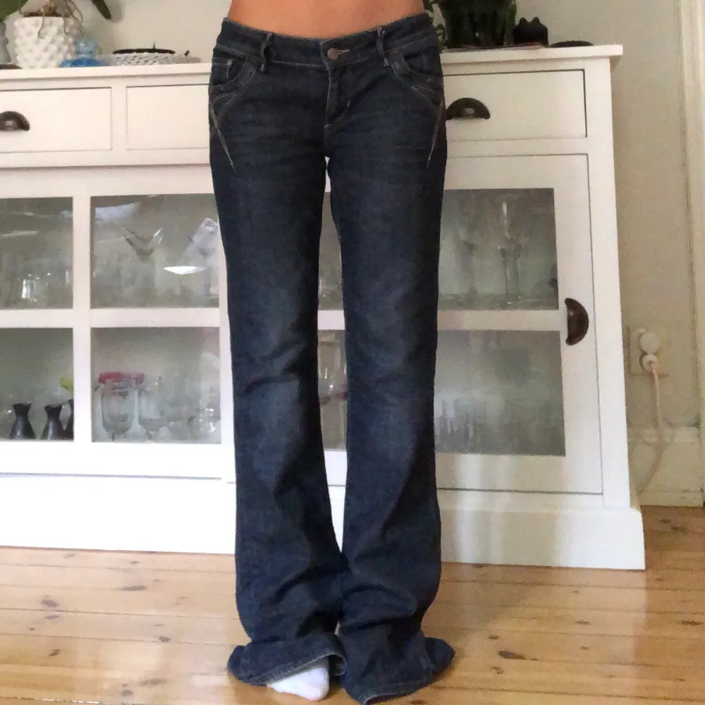 Mörkblå lågmidjade jeans med fina detaljer! Jättebra skick❤️ Jag är 161cm och de är väldigt långa på mig. Midjemått: 85cm Innerbenslängd: 85cm Använder ej funktionen frakt 63kr❗️. Jeans & Byxor.