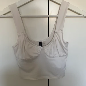 Vit Topp - Säljer denna jättesöta topp från HM. Aldrig använd eftersom den är för liten för mig. Väldigt bra skick💕💕