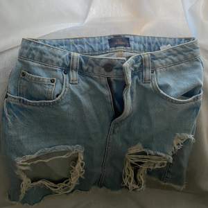 En jeanskjol i ljus jeans färg från Nly. Stora snygga slitningar i fram. Storlek 34