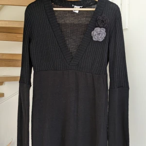 Svart stickad klänning  - Svart stickad klänning med blomma Storlek L