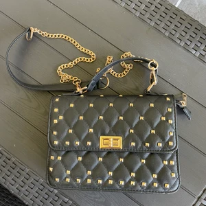 Väska - Nypris: 299kr. Är i nyskick. Har gulddetaljer. Frakt tillkommer och köparen står för frakten.